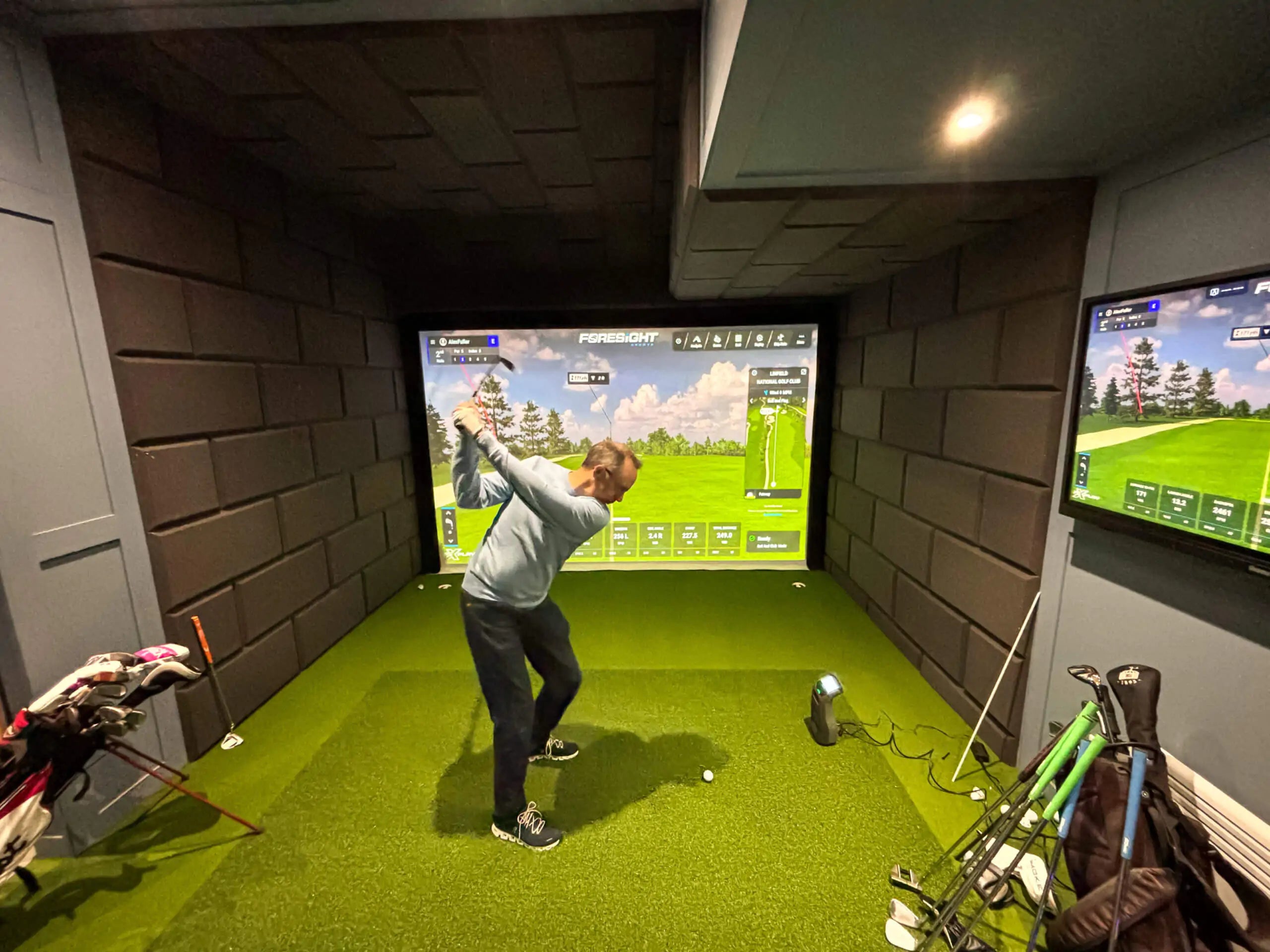 the best golf simulators rear view with golfer swinging